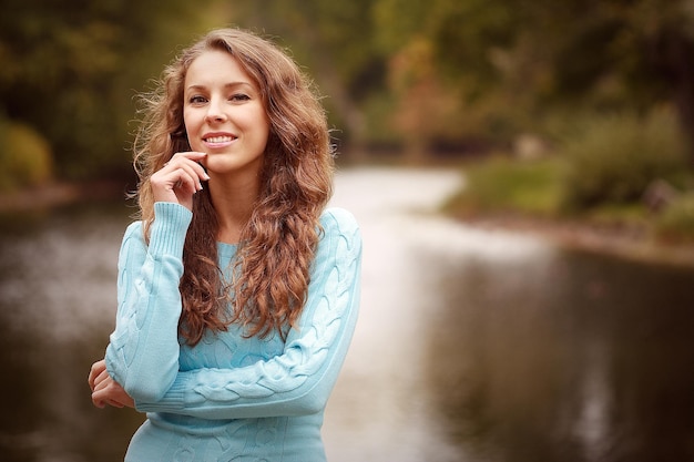 Femme près de la rivière en saison d'automne