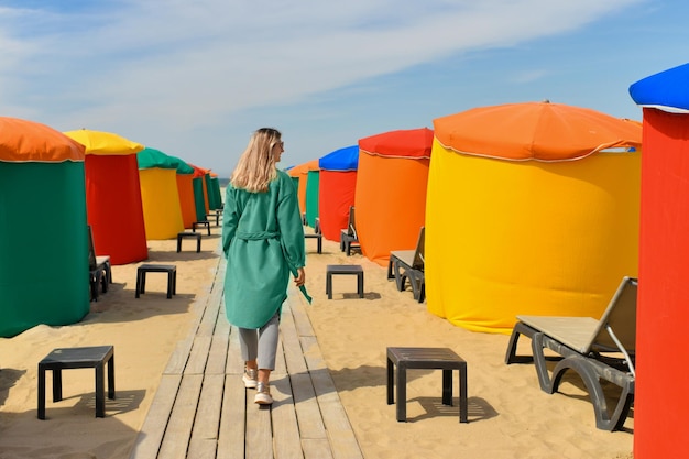 Une femme près des tentes typiques et des chaises de plage