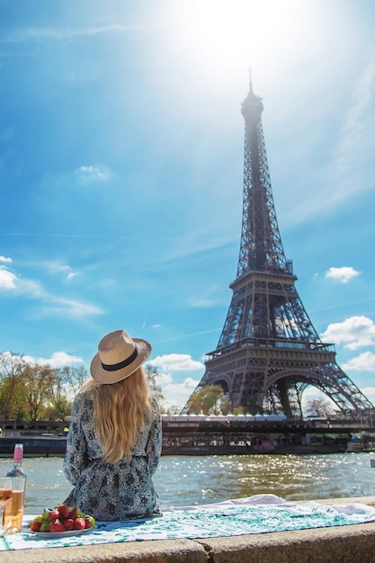 Une femme près de la Tour Eiffel boit du vin Mise au point sélective