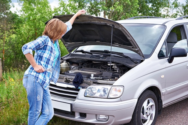 Photo femme près de voiture cassée