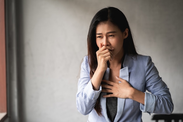 la femme présente des symptômes de toux et de fièvre