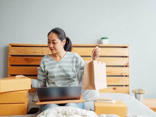 Femme prête à expédier les produits de sa boutique en ligne au client.