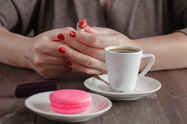 Femme prête à rouge à lèvres après le café expresso