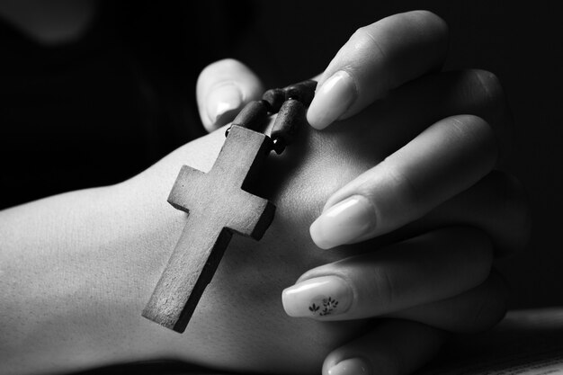 Femme priant sur book holding cross