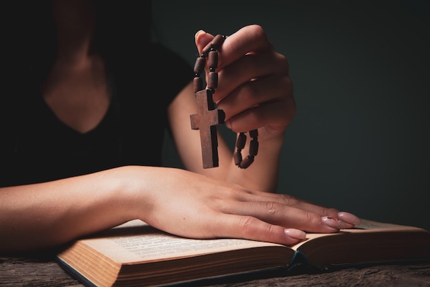 Femme priant sur book holding cross