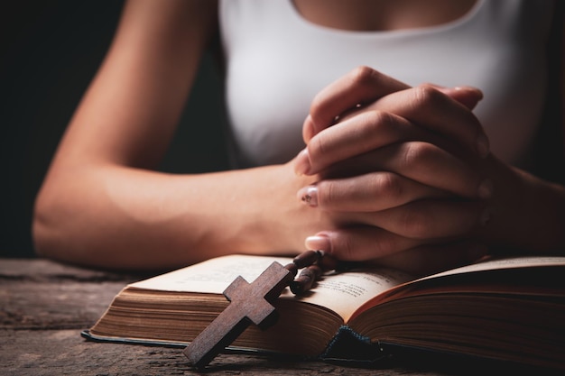 Femme priant sur book holding cross