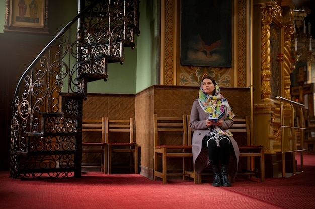 Femme priant à l'église pour le pèlerinage religieux