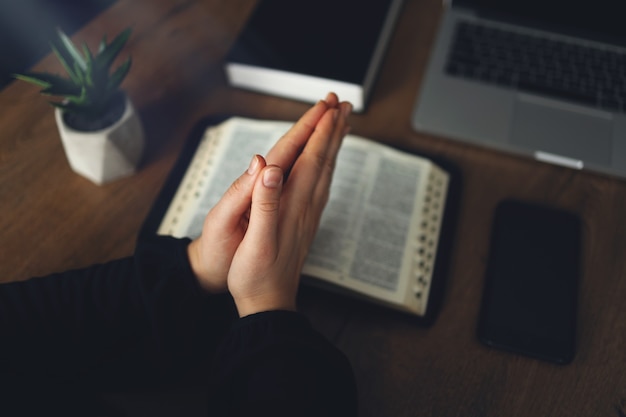 Femme priant par la foi avec un ordinateur portable, concept en ligne des services de l'église, concept d'église en ligne à la maison, spiritualité et religion.