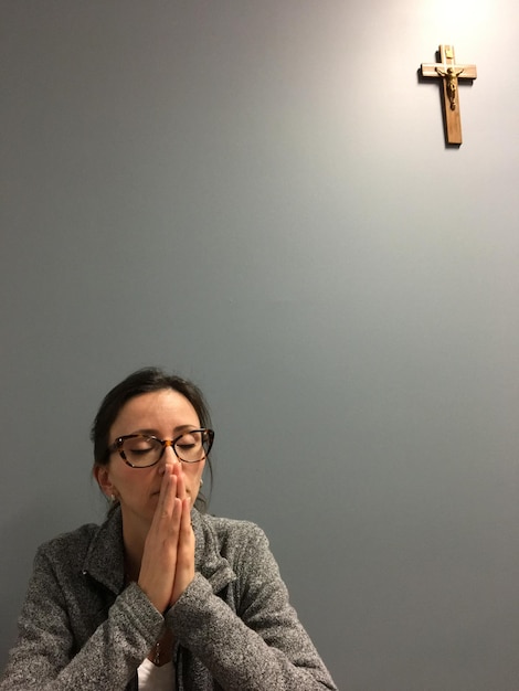Une femme prie contre le mur.