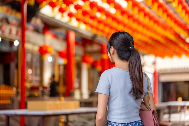 Une femme prie pour ses souhaits dans un temple chinois