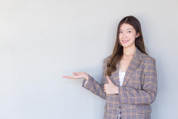 Femme professionnelle asiatique aux cheveux longs noirs assez souriante est un produit présent sur fond blanc