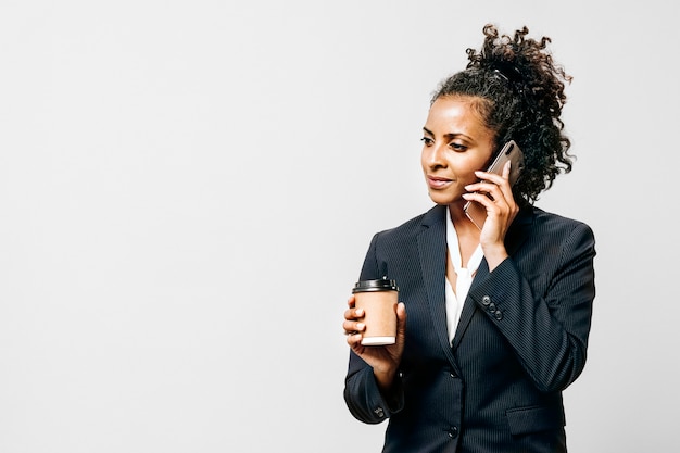 Femme professionnelle avec un café et un smartphone