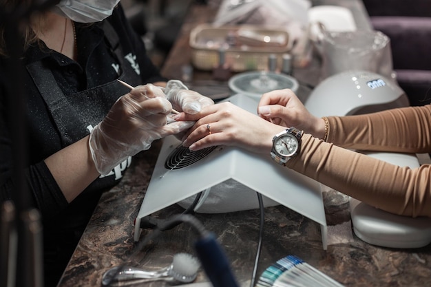 Femme professionnelle fait une manucure dans un salon de beauté