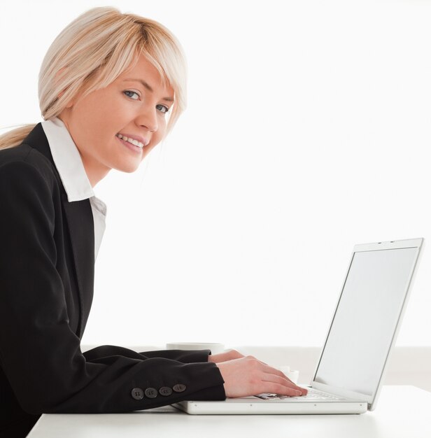 Femme professionnelle posant tout en vous relaxant sur un ordinateur portable