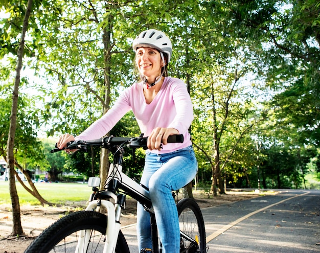 Femme profitant d&#39;une balade à vélo dans le parc