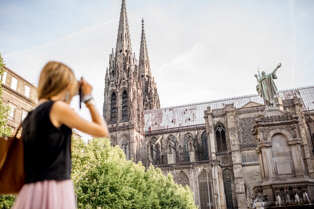 Photo femme profitant de la vue matinale sur la célèbre cathédrale de la ville de clermont-ferrand en france. la femme est floue