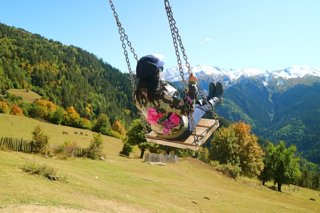 Femme profiter de la balançoire avec vue panoramique imprenable sur la montagne du Caucase dans la ville de Mestia en Géorgie