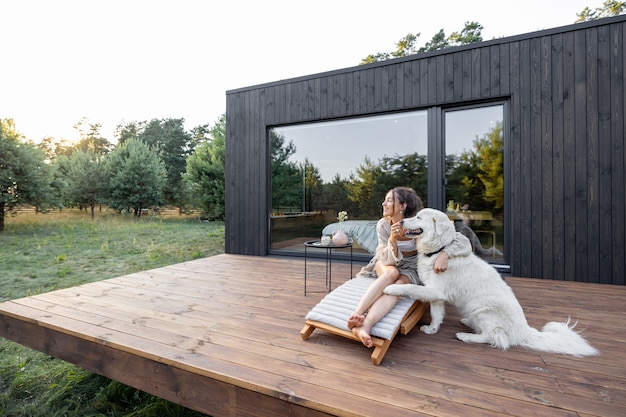 Femme profiter de la nature à la maison de campagne avec animal de compagnie