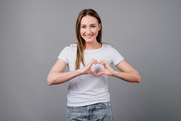 Femme, projection, forme coeur, à, elle, mains, isolé, sur, gris