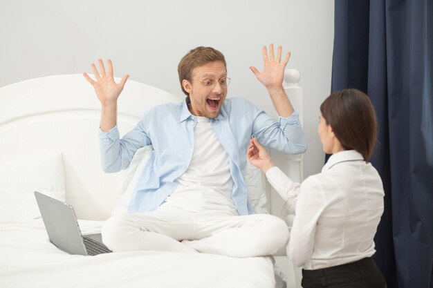 Femme proposant à l'homme dans la chambre. Bel homme avec une expression de visage fou surpris par sa proposition de copines