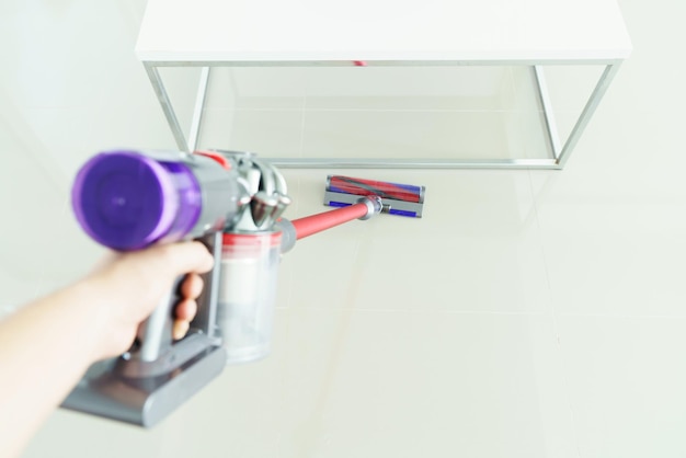 Photo femme propre sol avec un aspirateur à la maison