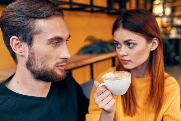 une femme en pull et un homme dans un café une tasse de café un couple amoureux amis famille photo de haute qualité