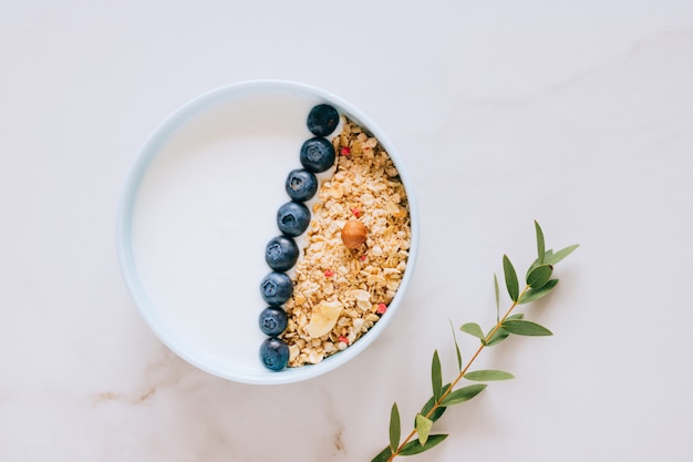 Femme en pull de laine gris mangeant du porridge de riz à la noix de coco avec figues, baies et noisettes