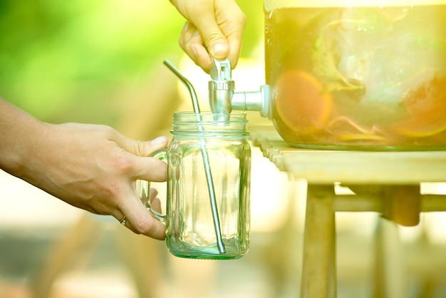 Femme puring limonade dans son pot masson