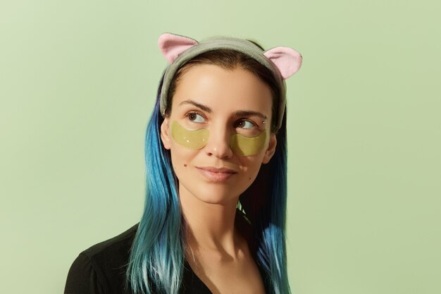 Femme en pyjama avec cache-œil sur fond vert pastel