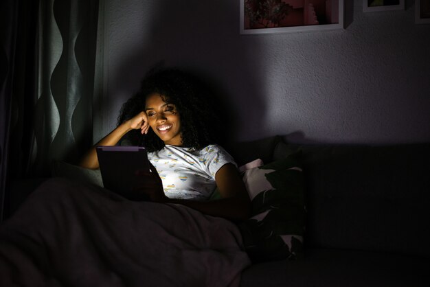 Femme en pyjama avec une tablette