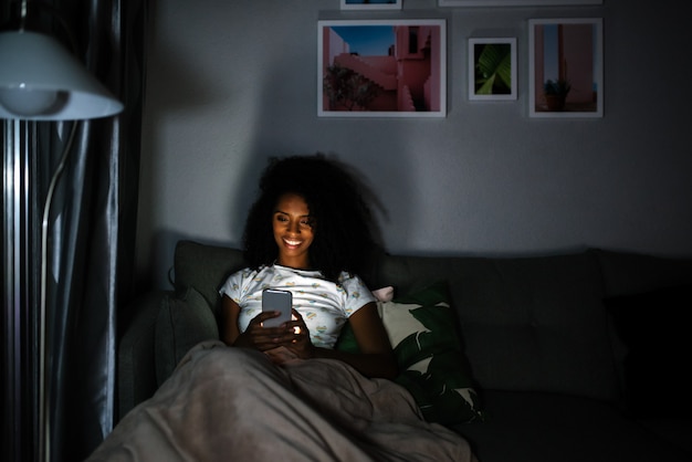 Femme en pyjama avec un téléphone portable