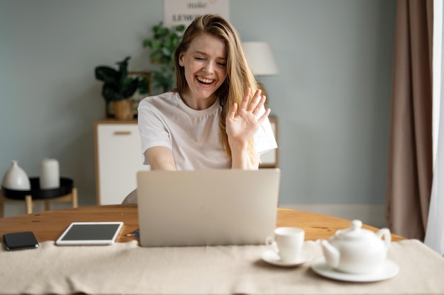 Une femme qui apprend en ligne à la maison utilise un ordinateur portable et un site Internet