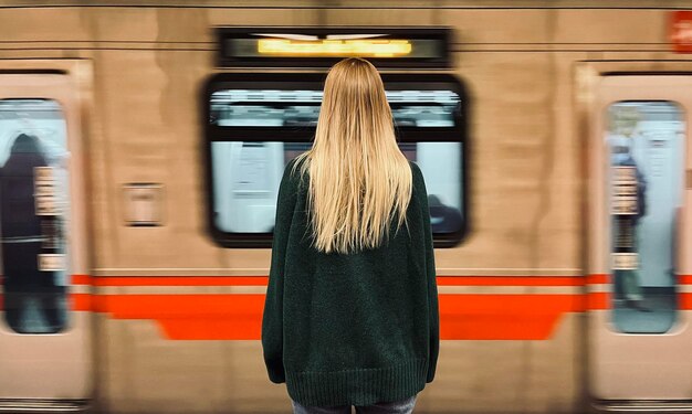 Photo une femme qui attend un train dans le métro.