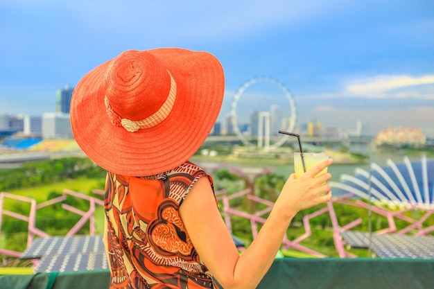 Photo une femme qui boit du jus contre le paysage urbain moderne