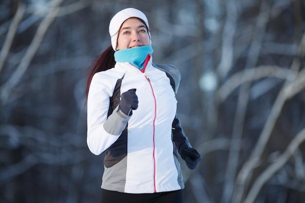 Femme qui court dans le parc d'hiver