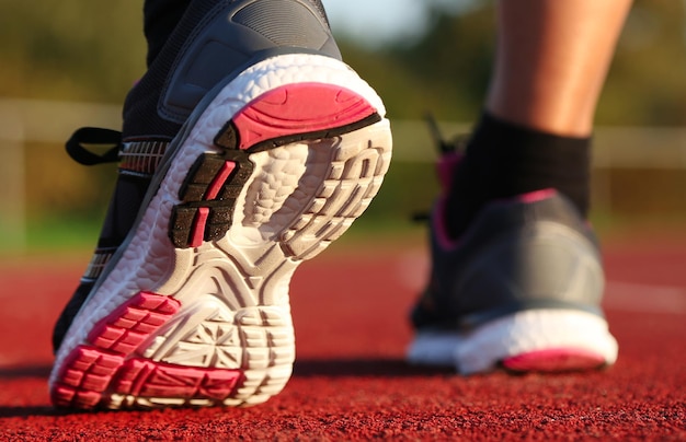 Femme qui court sur la piste d'athlétisme à l'après-midi