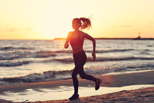 femme qui court seule au beau crépuscule sur la plage