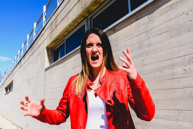 Une femme qui crie contre le mur.