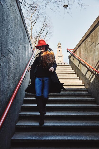 Photo une femme qui descend l'escalier en pleine longueur.