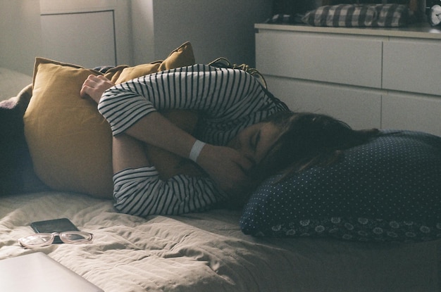 Une femme qui dort sur un lit à la maison.