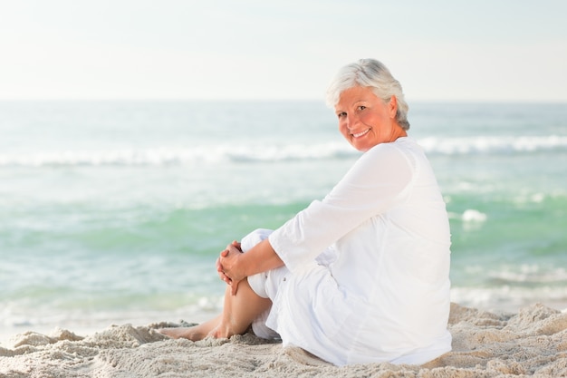 Femme qui est assise sur la plage