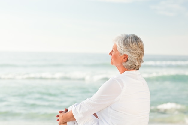 Femme qui est assise sur la plage