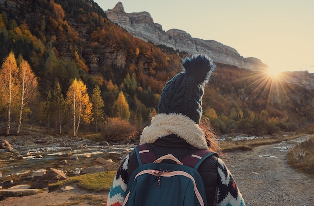 Femme qui marche à côté d'une rivière dans les montagnes. Personne en randonnée dans la forêt à l'automne. Parc Naturel d'Ordesa et Monte Perdido dans les Pyrénées