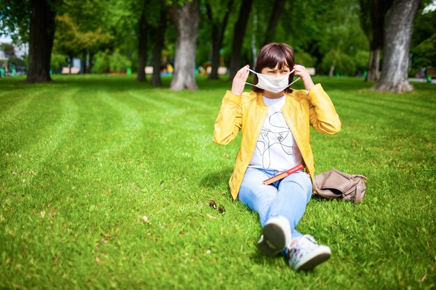 Femme qui marche dans le parc portant un masque de protection