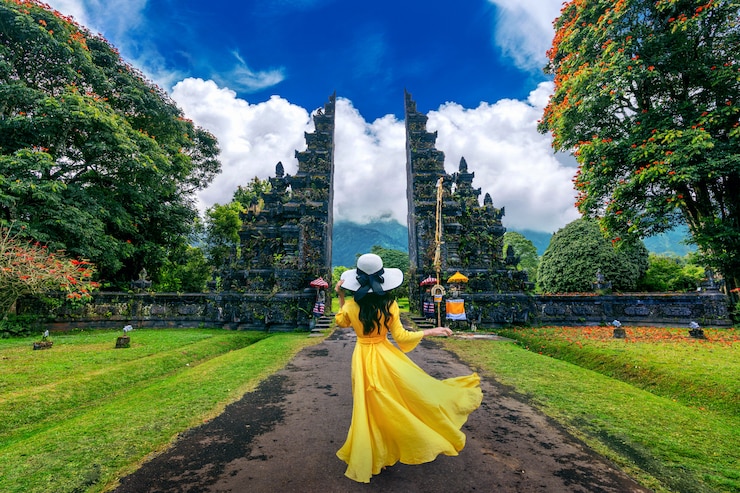 Photo femme qui marche à la grande porte d'entrée, bali en indonésie.