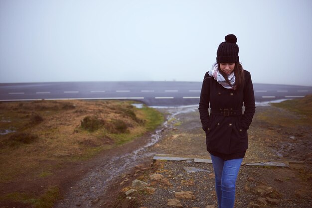 Photo une femme qui marche sur la terre contre le ciel