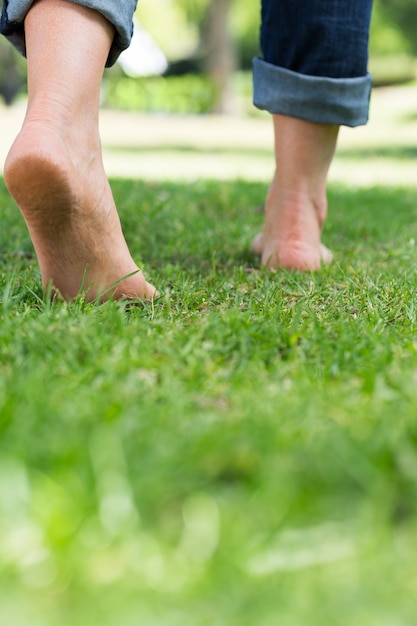 Femme qui marche sur la terre herbeuse