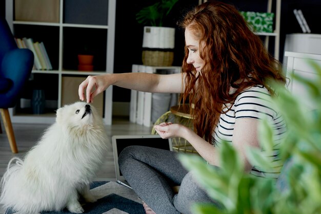 Femme qui nourrit un chien à la maison