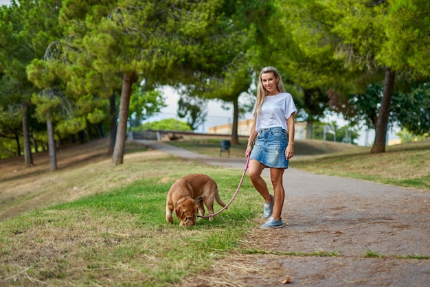 Femme qui promène le chien dans le parc.