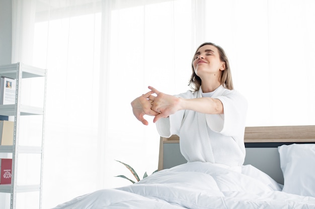 Femme qui s'étend après s'être réveillé le matin.